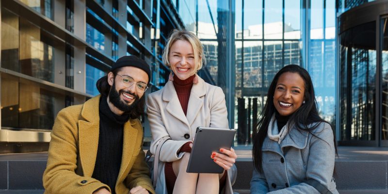 business-colleagues-looking-at-camera-and-smile-while-sitting-on-the-stairs-outside-the-office.jpg